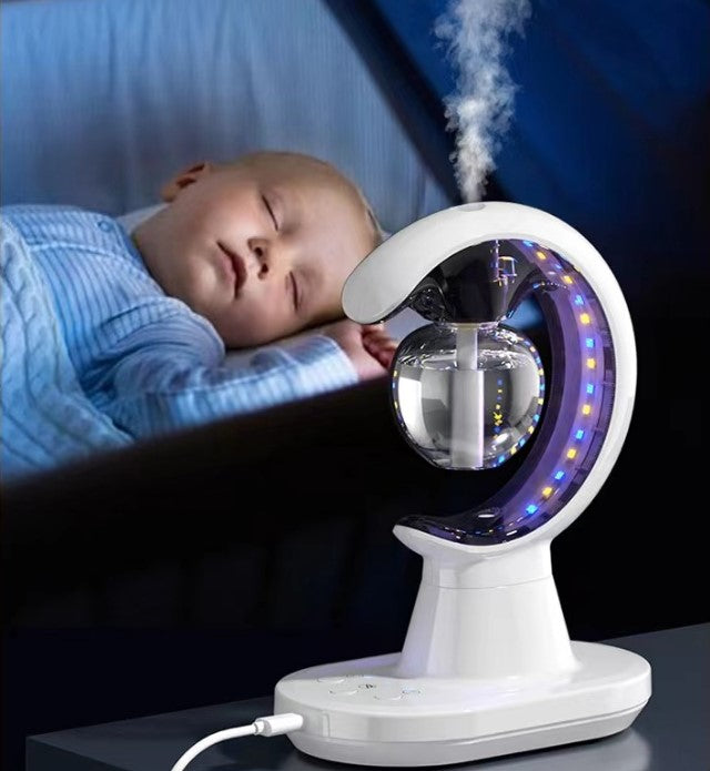 Baby sleeping next to a humidifier with LED lights on a dark background