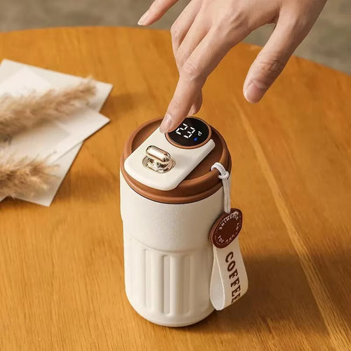 White and brown thermos with digital display on a wooden table