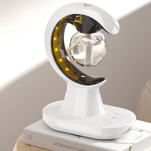 White lamp shaped like a crescent moon on a book with a plain background
